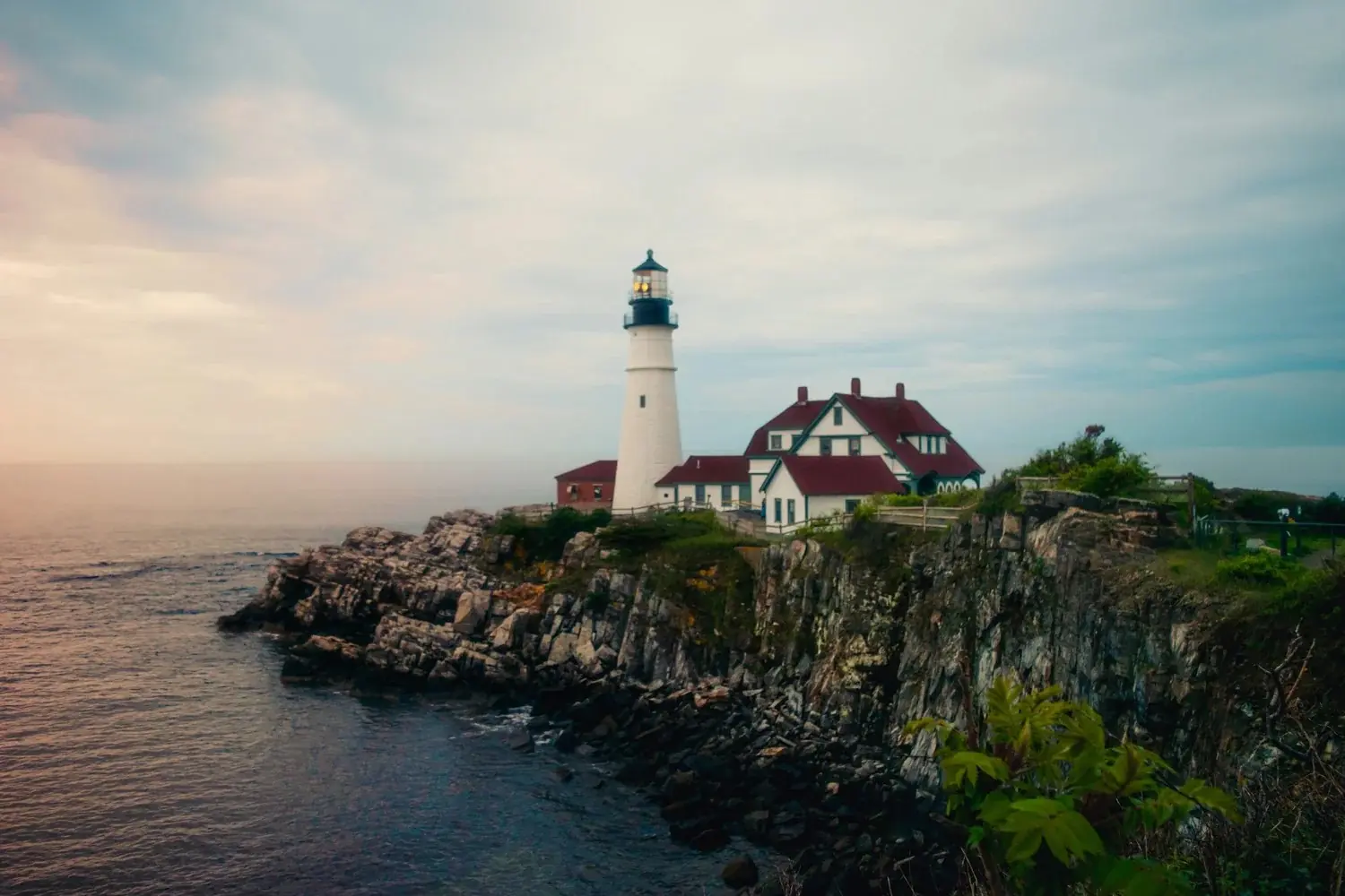 Portland Head Light and its keeper’s house on the rocky Maine coast at dusk.